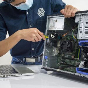 A technician repairs a desktop computer in an indoor setting, illustrating tech maintenance.